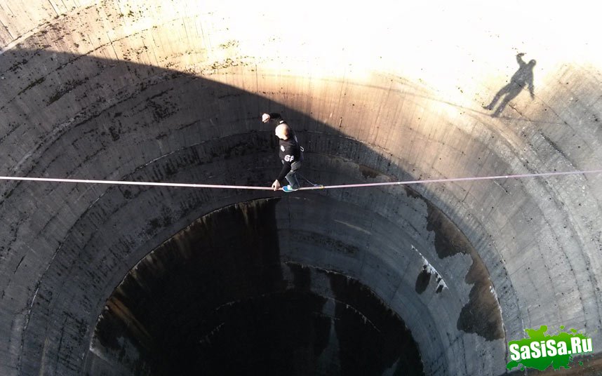 Смельчак слэклайнер пересекает 61-метровый слив водохранилища (9 фото)