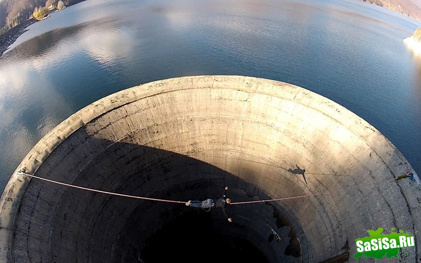 Смельчак слэклайнер пересекает 61-метровый слив водохранилища (9 фото)